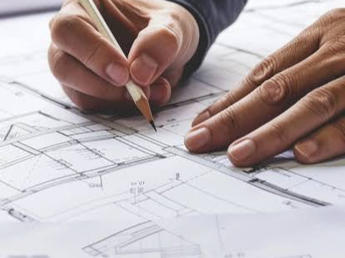 An architect hand-drafting a building floor plan